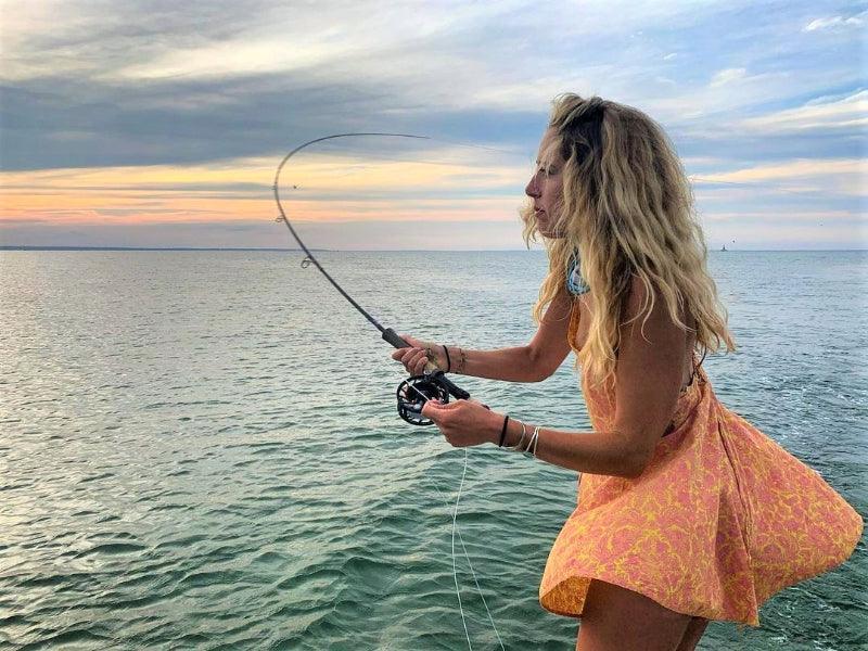woman fly fishing on boat charter tour