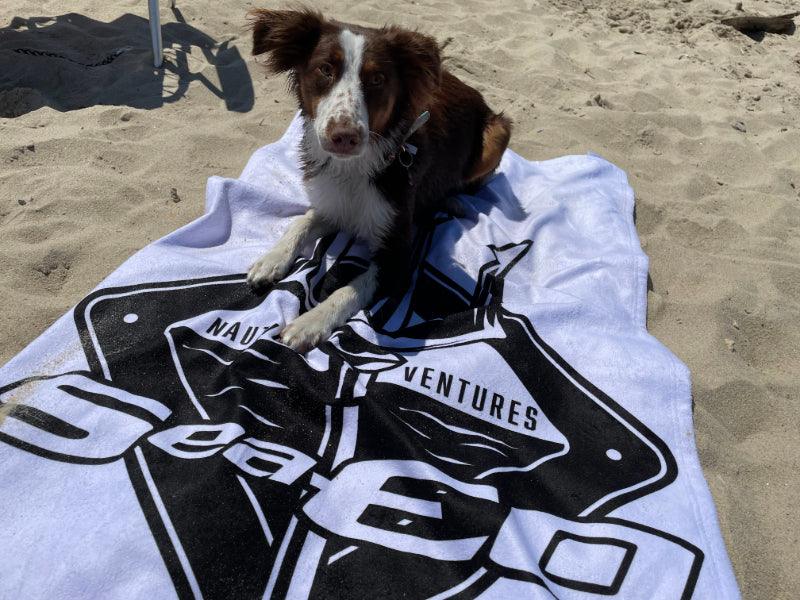 dog on SeaEO branded towel on the beach