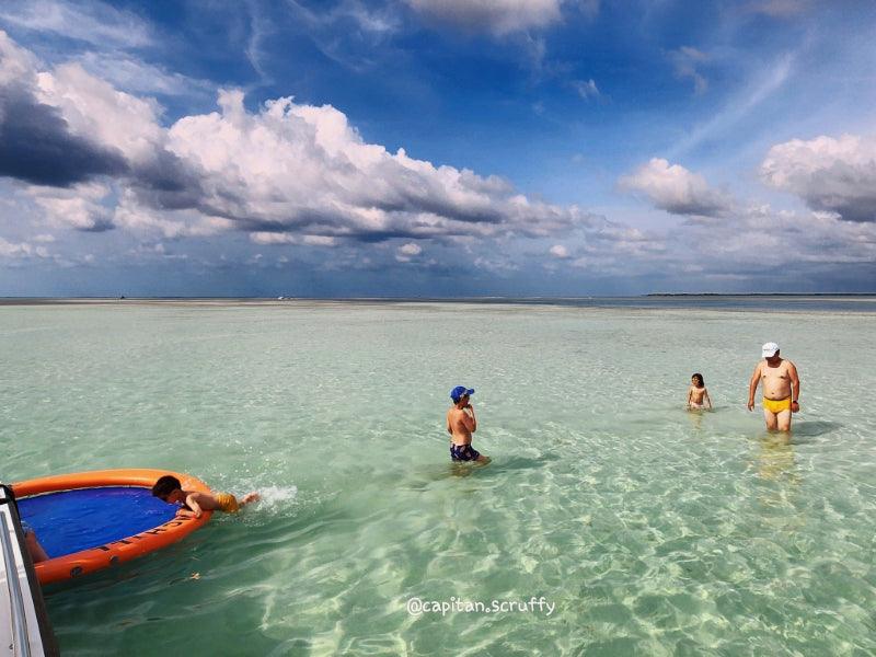 family in ocean by sandbar boat charter