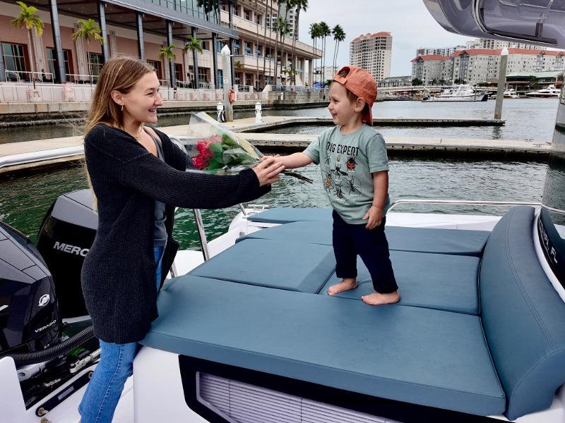 child giving flowers to woman on charter boat