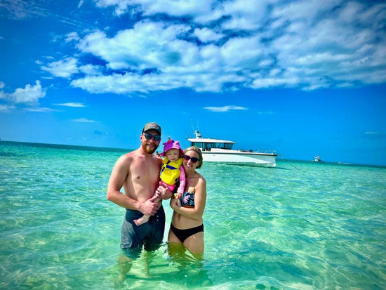 family in ocean by the boat